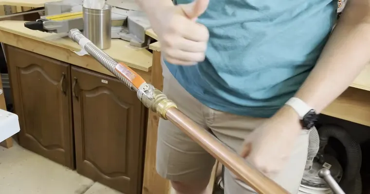 Plumbing technician working on visible pipe connections for PEX-A vs Copper Repiping in Tolleson's Hard Water: What the Difference Means The repair area is visible from a closer angle.