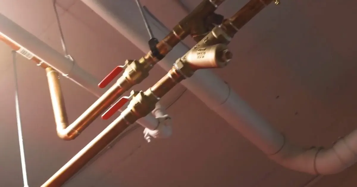 Plumbing technician working on visible pipe connections for PEX-A vs Copper Repiping in Tolleson's Hard Water: What the Difference Means