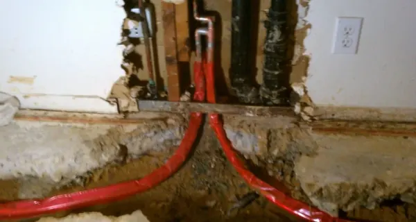 Plumbing technician working on visible pipe connections for Tolleson plumbing homepage